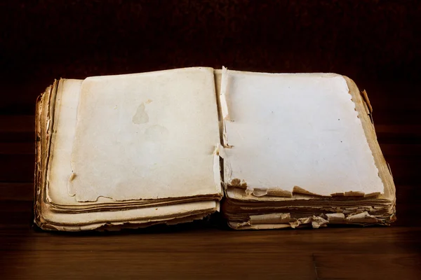 空白のページがヴィンテージの木製のテーブル上のテキストの古い本を開く — ストック写真