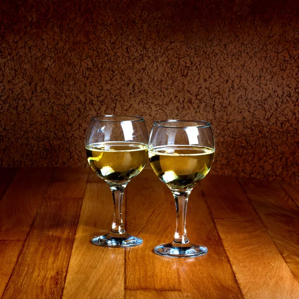 Two wineglasses of white wine on wooden old counter top — Stock Photo, Image