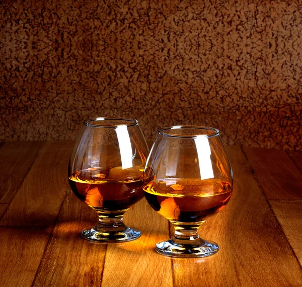 Two goblets of brandy on wooden old counter top — Stock Photo, Image