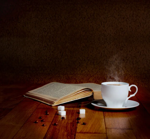 Warme kop van verse koffie op de houten tafel en een stapel boeken — Stockfoto