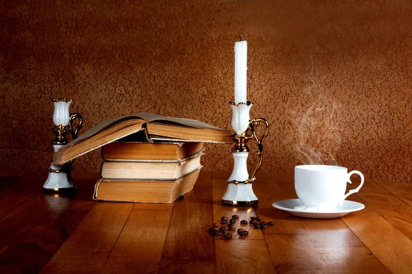 Heiße Tasse frischen Kaffee auf dem Holztisch mit Kerze und Buch — Stockfoto