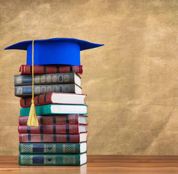 Graduation mortarboard on top of stack of books — Stock Photo, Image