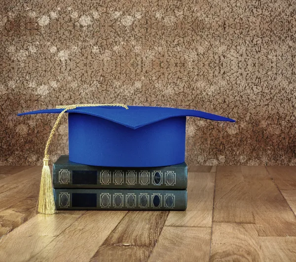 Afstuderen mortarboard op boeken — Stockfoto