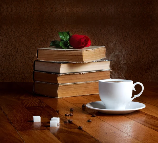 Taza caliente de café fresco en la mesa de madera y pila de libros —  Fotos de Stock