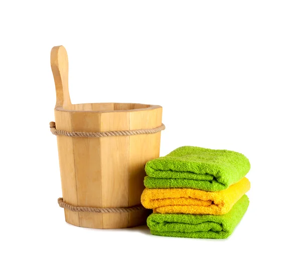 Cubo de madera con cucharón para la sauna y pila de toallas limpias —  Fotos de Stock