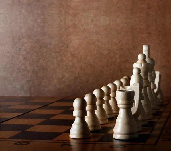 Houten schaakbord met cijfers over groene tafel en oude muur — Stockfoto