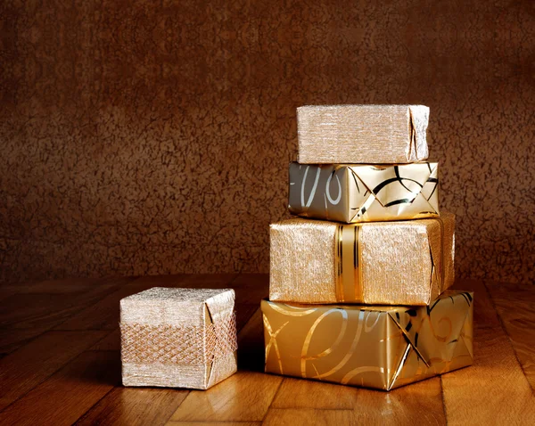 Gift box in gold wrapping paper — Stock Photo, Image