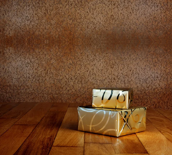 Gift box in gold wrapping paper — Stock Photo, Image