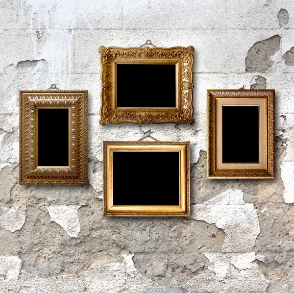 Molduras de madeira dourada para fotos na parede de pedra velha — Fotografia de Stock