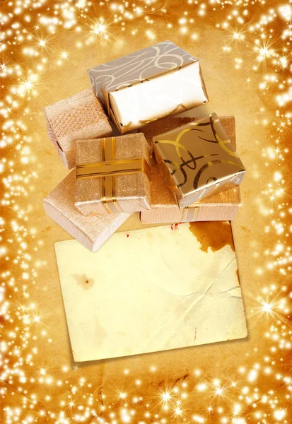 Подарочная коробка в золотой оберточной бумаге на винтажном картонном фоне — стоковое фото