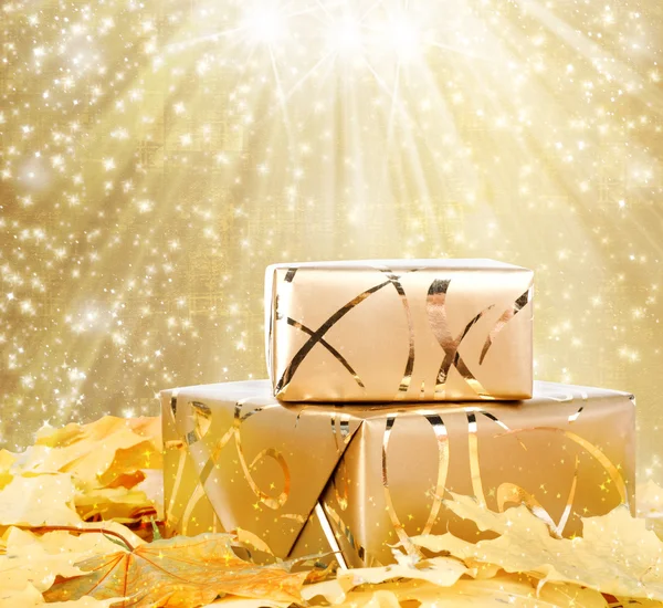 Coffret cadeau en papier d'emballage doré avec feuilles d'automne sur l'abstra — Photo