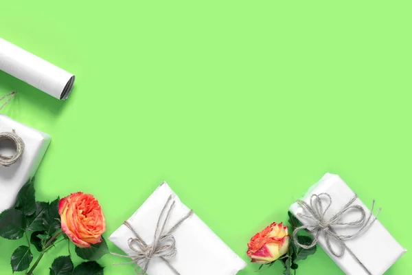 礼品盒装在包装纸上 用绳子捆着 用红黄的玫瑰束在绿色背景上祝贺你 创意假日礼物 — 图库照片