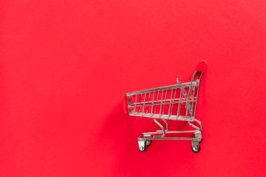 Kırmızı arka planda hediye kutusu olan market alışveriş arabası.. 
