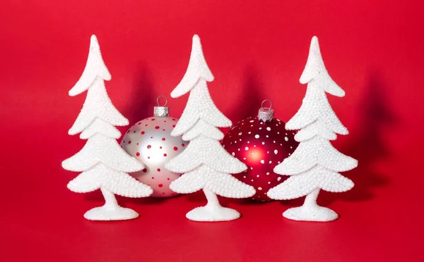 Kerstkaart Met Besneeuwde Witte Nieuwjaarsbomen Kleurrijke Ballen Felrode Achtergrond — Stockfoto