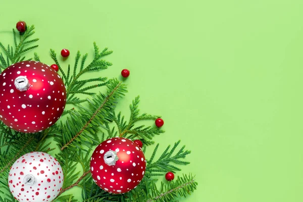 五彩缤纷的圣诞球 绿纸背景上有树枝和浆果 新年创意贺卡 — 图库照片