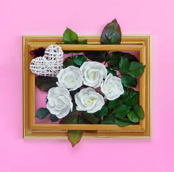 情人节那天 美丽的白色玫瑰 绿叶绿叶 心形古旧木框 挂在明亮的粉红墙上 创意贺卡 — 图库照片
