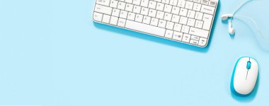 Laptop, aksesuarlar ve mavi arka planda kalem. Çalışma yerinin düzlüğü. 