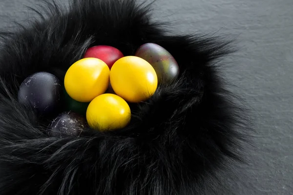 Black Fur Nest Painted Yellow Eggs Dark Stone Table Festive — Stock Photo, Image