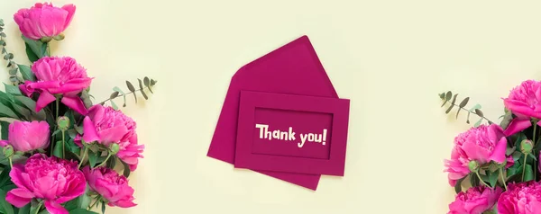封筒と黄色の紙の背景に手紙を持つ美しい繊細なピンクの牡丹 カードにレタリングしてくれてありがとう 創造的なデザイン サービスへの感謝 — ストック写真