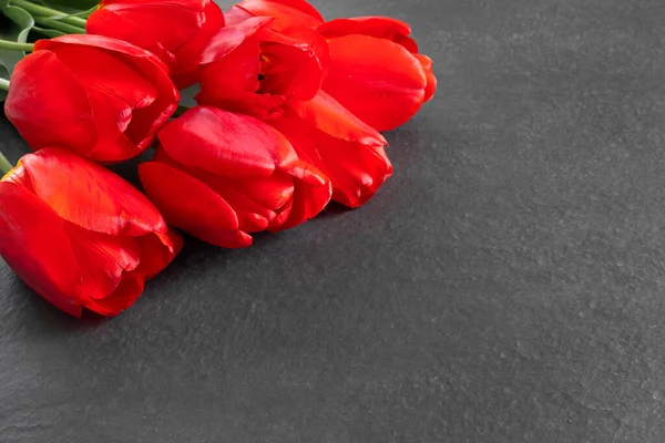 Kytice Krásných Červených Tulipánů Černé Žulové Památce Prázdným Prostorem Pro — Stock fotografie