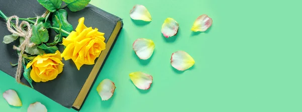 美丽的黄色玫瑰花束 有古籍书 绿色桌子上有花瓣 总部和假日请柬或贺书 — 图库照片