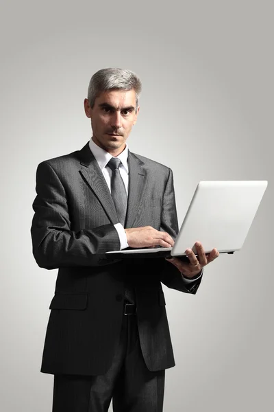 Smiling handsome businessman working with laptop. Isolated over white background — Stock Photo, Image