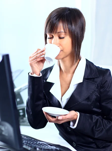 Empresária sentada à mesa no lobby do escritório, bebendo café . — Fotografia de Stock