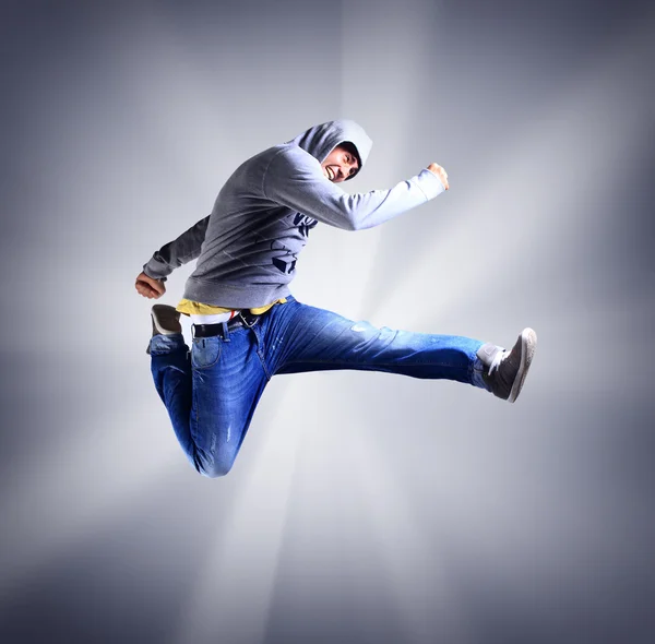 Спортивный портрет молодого человека, прыгающего в воздухе на светлом фоне — стоковое фото