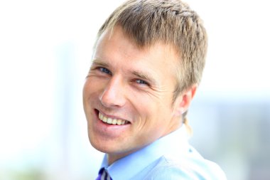 ofisinde gülümseyen genç işadamı portresi.