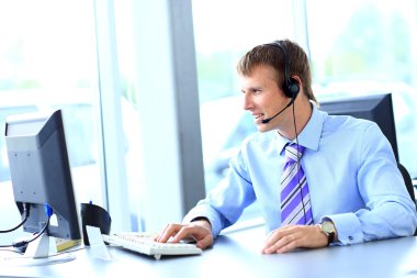 kulaklık kullanarak callcenter çalışma mutlu genç adam