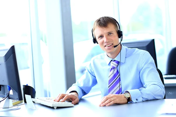 Šťastný mladý muž pracuje v callcenter, pomocí headsetu — Stock fotografie