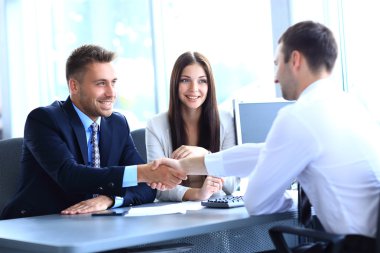 businessman shaking hands to seal a deal with his partner clipart