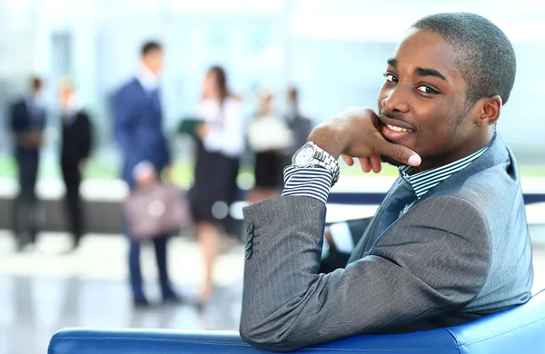 Se usmívám africké americké obchodní muž s pracovníky pracující v pozadí — Stock fotografie