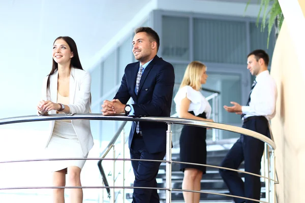 Retrato de grupo empresarial positivo em pé nas escadas do escritório moderno — Fotografia de Stock