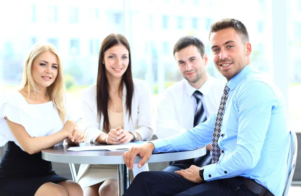 Hombre de negocios feliz con colegas en una conferencia en el fondo — Foto de Stock