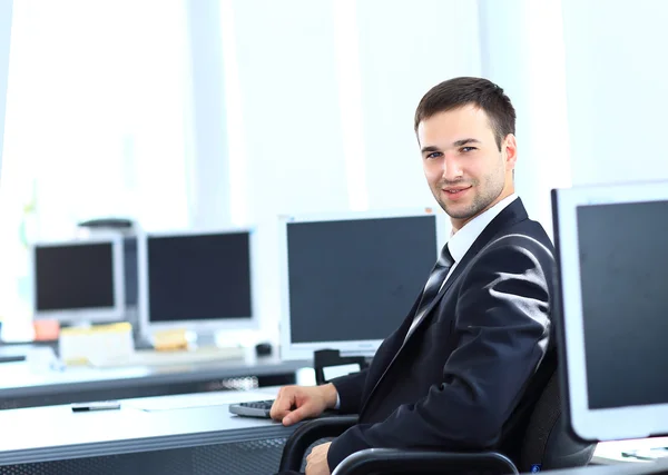 Νεαρός επιχειρηματίας που εργάζεται στο γραφείο, κάθεται στο γραφείο — Φωτογραφία Αρχείου