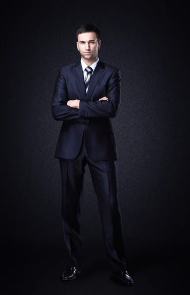 Businessman standing on dark gradient background — Stock Photo, Image