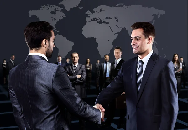 Porträtt av unga företagare. Handshake framför affärsmän — Stockfoto