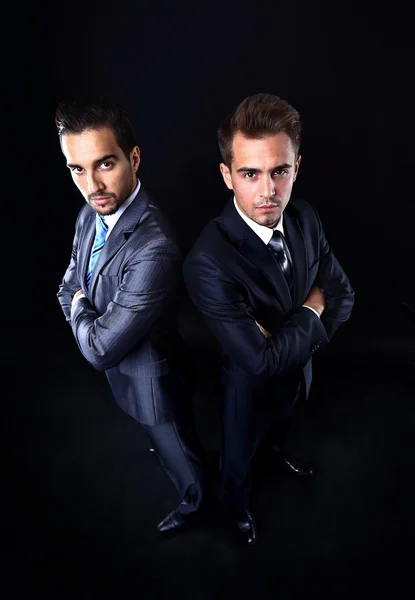 Two young businessmen full body, isolated on black — Stock Photo, Image