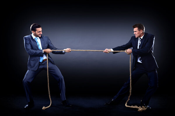 Two business men pulling rope in a competition, isolated on white background