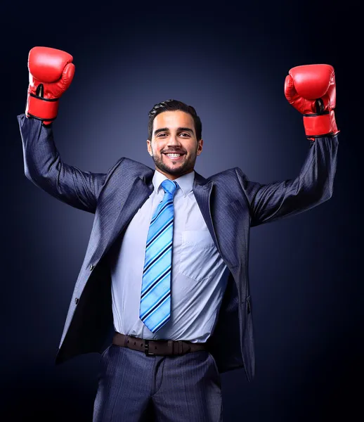 Businessman in a suit and boxing gloves, celebrating a win, isolated on black background — Stock Photo, Image
