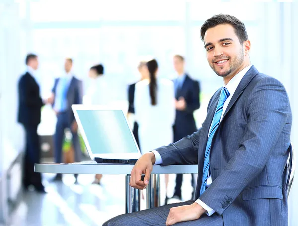 Glad ung affärsman med laptop i företag byggnad — Stockfoto