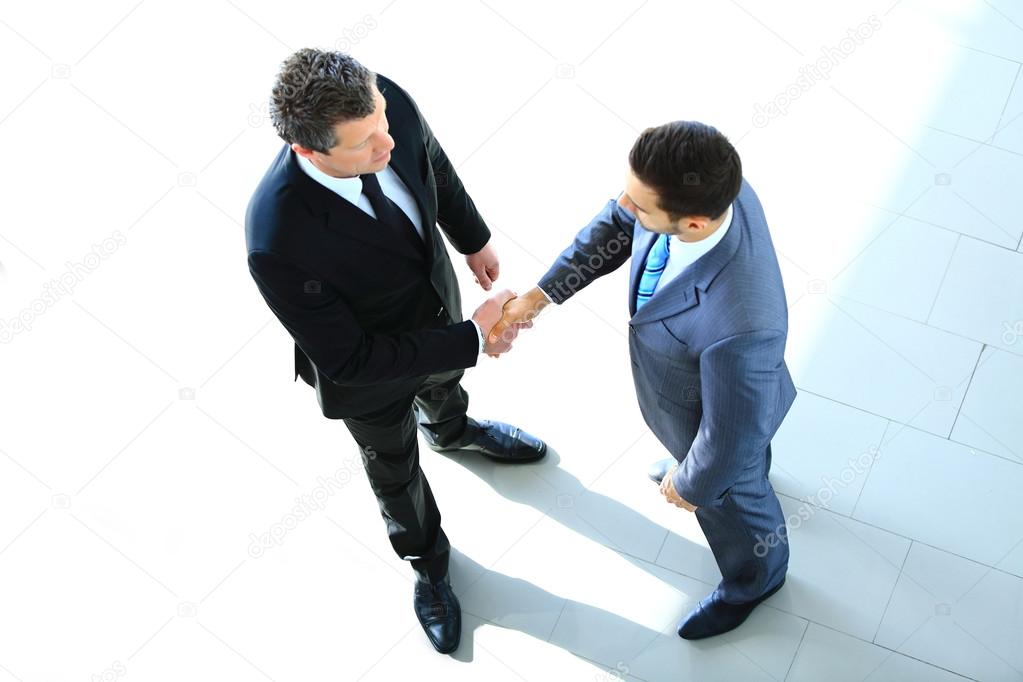 Top view of a two businessman shaking hands - Welcome to business