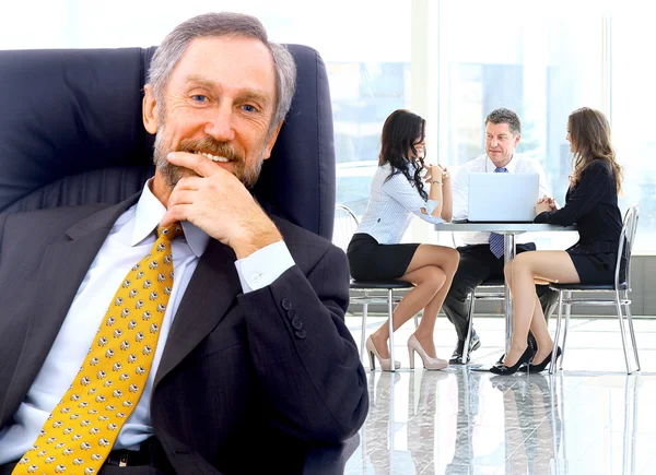 Homme d'affaires prospère debout avec son personnel en arrière-plan au bureau — Photo