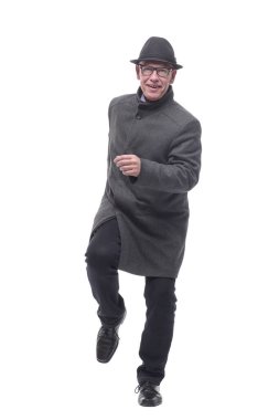 Şapkalı ve sonbahar montlu neşeli bir adam ileri doğru yürüyor. .