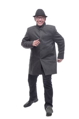 Şapkalı ve sonbahar montlu neşeli bir adam ileri doğru yürüyor. .