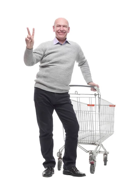 W pełnym wzroście. szczęśliwy człowiek z wózkiem na zakupy. — Zdjęcie stockowe