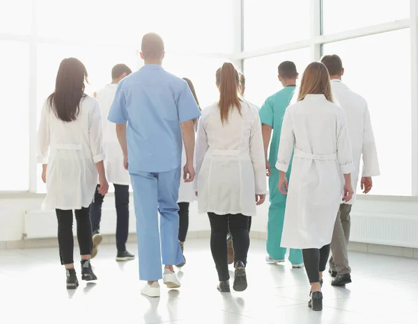 Vista trasera. médicos del centro médico caminando por el pasillo —  Fotos de Stock