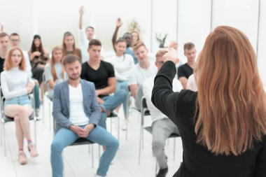 Dikiz aynası. Kadın konuşmacı konferans odasında konferans veriyor..