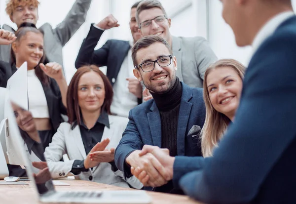 Equipo de negocios jubiloso mirando el apretón de manos de los socios comerciales — Foto de Stock